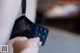 A close up of a woman's hand holding a black bra.