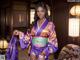 A woman in a purple kimono posing for a picture.