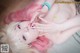 A woman with pink hair is laying on the floor.