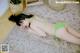 A woman in a green bikini laying on a rug.