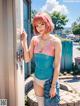 A woman in a pink and blue bathing suit leaning against a door.