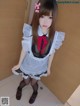 A woman in a maid outfit posing for a picture.