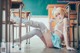 A woman sitting on the floor in front of a classroom.