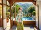 A woman in a green kimono standing in front of a window.