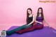 A couple of women sitting on top of a purple mat.