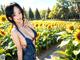 A woman in a sunflower field posing for a picture.