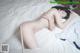 A naked woman laying on top of a bed.
