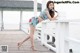 A woman leaning against a white fence on a pier.